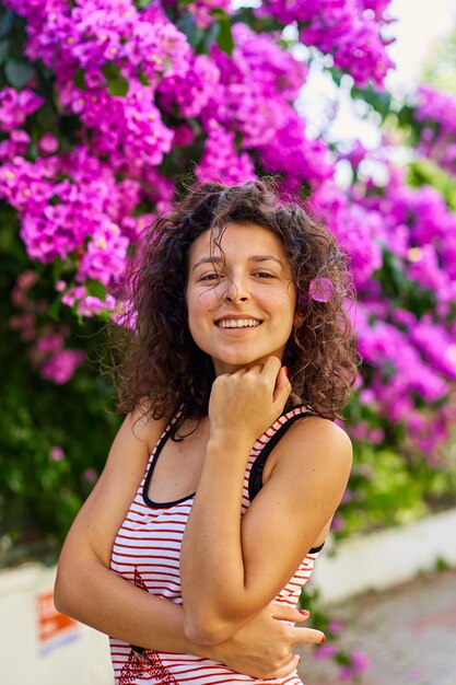 Foto linda jovem morena modelo posando com flores roxas desabrochando na turquia, na ilha de buyukada