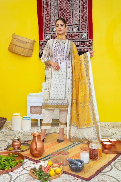 Linda jovem mostrando seu vestido tradicional em fundo amarelo