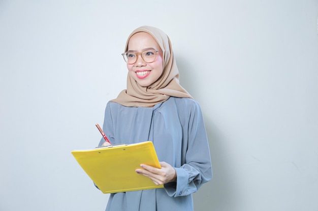 Linda jovem mulher de negócios muçulmana asiática segurando a área de transferência sobre fundo isolado