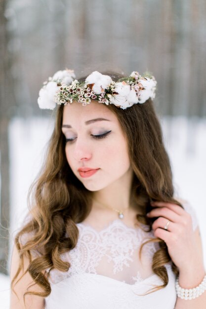 Linda jovem noiva na floresta de neve de inverno