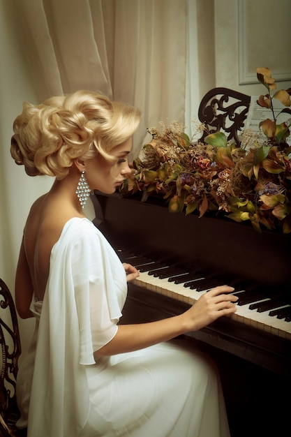 Linda jovem noiva tocando piano