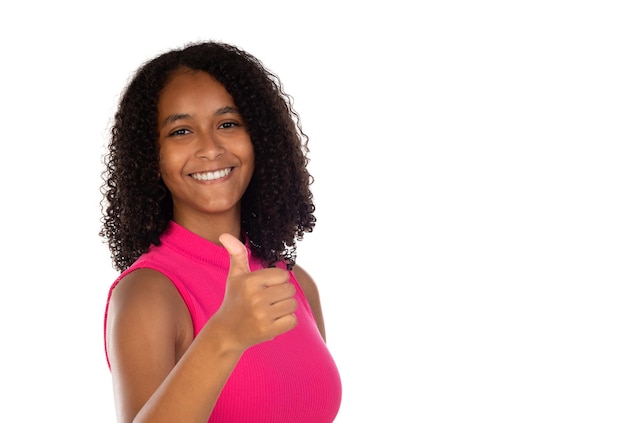 Linda jovem otimista afro-americana vestindo camiseta rosa contra a parede branca mostrando os polegares com emoções positivas