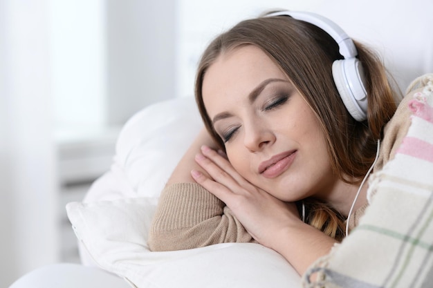 Linda jovem ouvindo música em casa