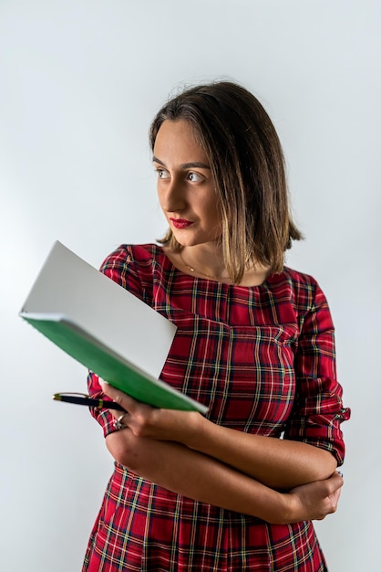 Linda jovem professora em pé com livros nas mãos isoladas em fundo liso