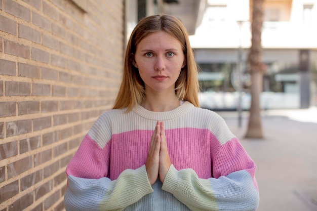 linda jovem se sentindo preocupada, esperançosa e religiosa orando fielmente