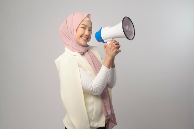 Linda jovem segurando o megafone sobre fundo branco studiox9