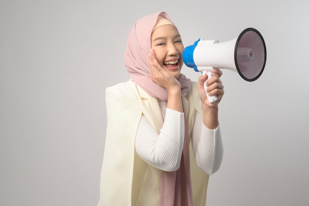 Linda jovem segurando o megafone sobre fundo branco studiox9