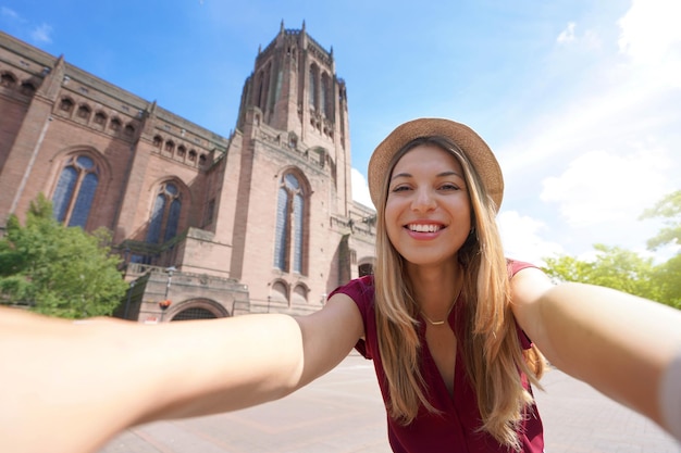 Linda jovem tirando foto de selfie em frente à Catedral de Liverpool, na Inglaterra, Reino Unido