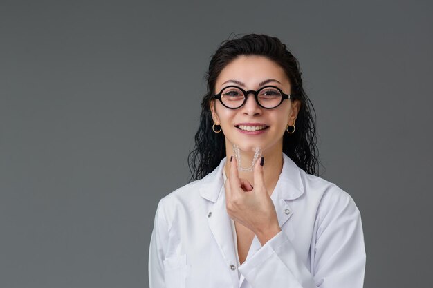 Linda jovem turca sorridente está segurando um invisaligner