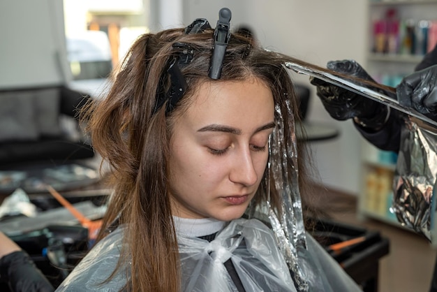 Linda jovem veio ao salão de beleza para coloração de cabelo O conceito de coloração de cabelo em etapas