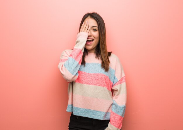 Linda joven gritando feliz y cubriendo la cara con la mano