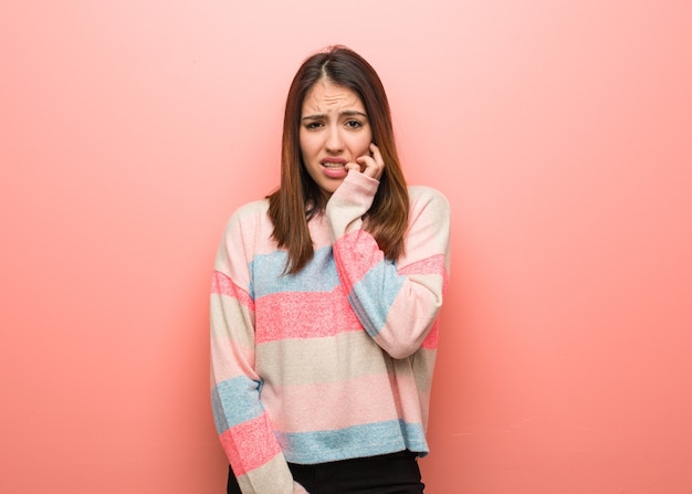 Foto linda joven mordiendo las uñas, nerviosa y muy ansiosa