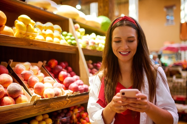 Una linda joven en una tienda de frutas