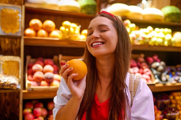 Una linda joven en una tienda de frutas