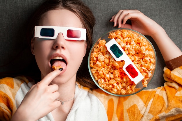 Linda jovencita comiendo palomitas de maíz