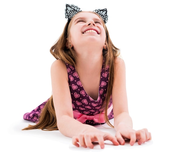 Una linda jovencita con orejas negras atadas de un gato tendido en el suelo sonriendo