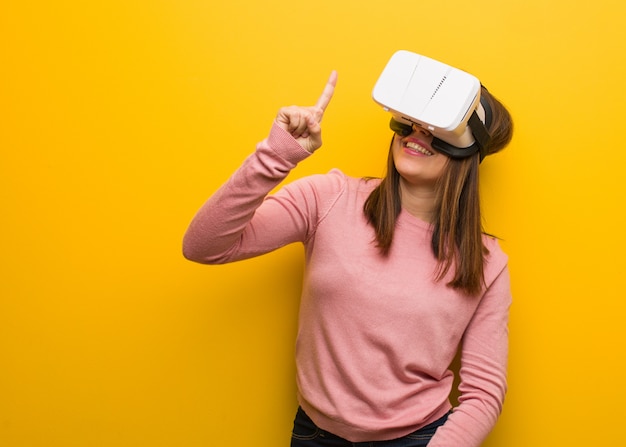 Linda jovencita vistiendo unas gafas de realidad virtual mostrando el número uno