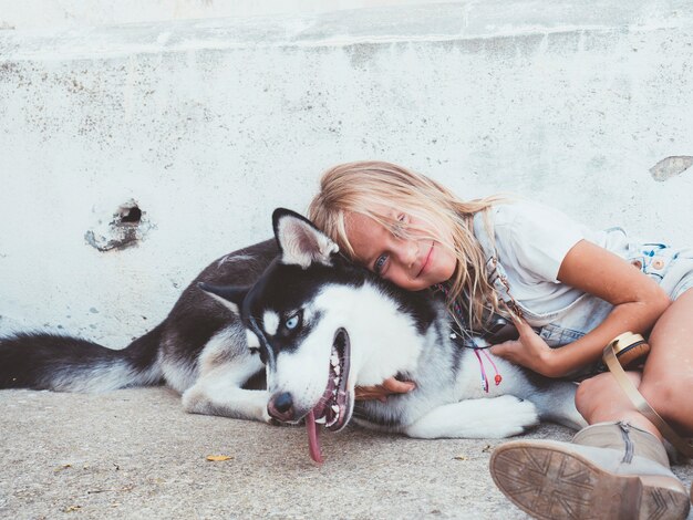 Linda loira posa com animal de estimação Husky siberiano