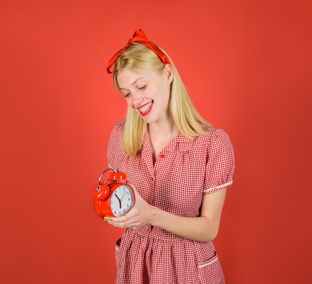 Linda loira segurando um despertador retrô, mulher sorridente com despertador, temporada de compras