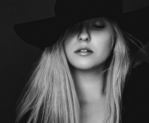 Linda loira usando um retrato de filme artístico de chapéu em preto e branco para campanha de moda e marca de beleza