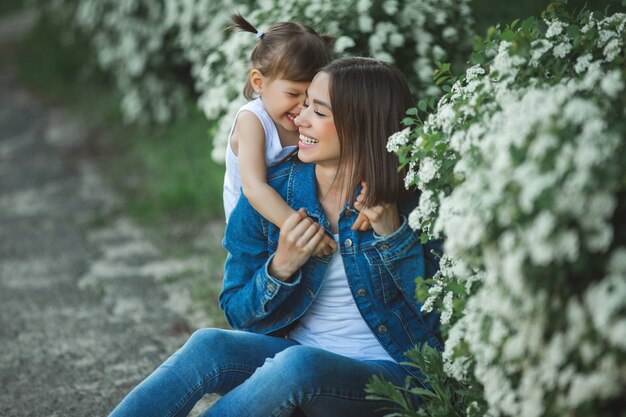 Foto linda madre e hija juntas. familia feliz al aire libre. niñas en flores. ypung mujer y su hijo