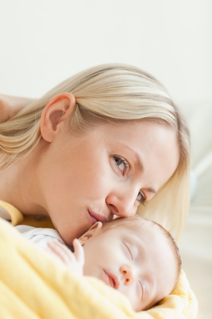 Linda mãe beijando seu bebê dormindo