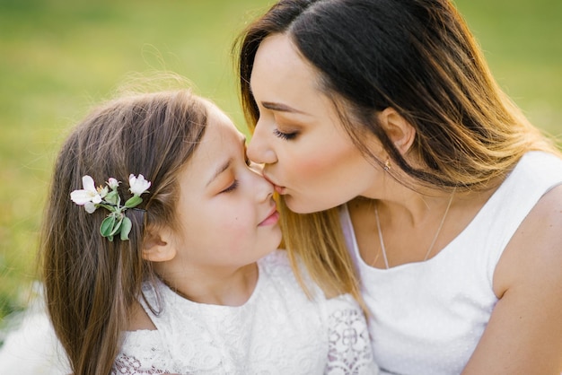 Linda mãe beijando sua filha no nariz