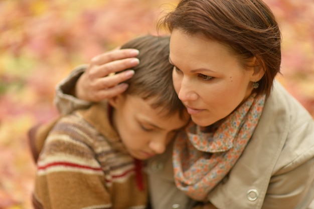 Linda mãe com filho no parque outono