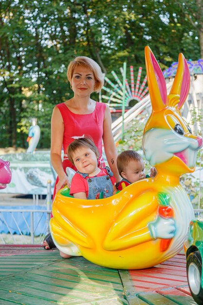 Linda mãe com uma menina e um menino na atração