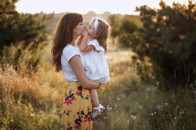 Linda mãe e filha brincando no campo