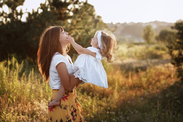 Linda mãe e filha em uma caminhada no campo