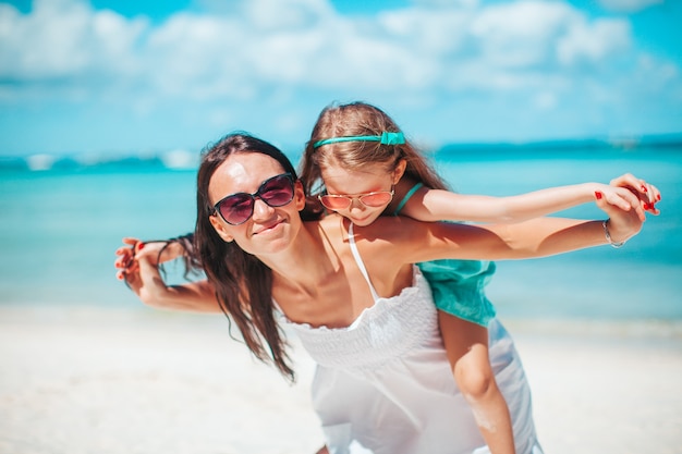 Linda mãe e filha na praia aproveitando as férias de verão