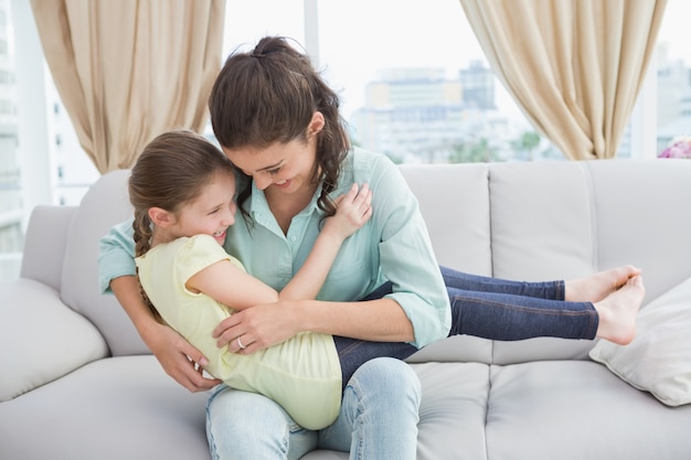 Linda mãe e filha no sofá