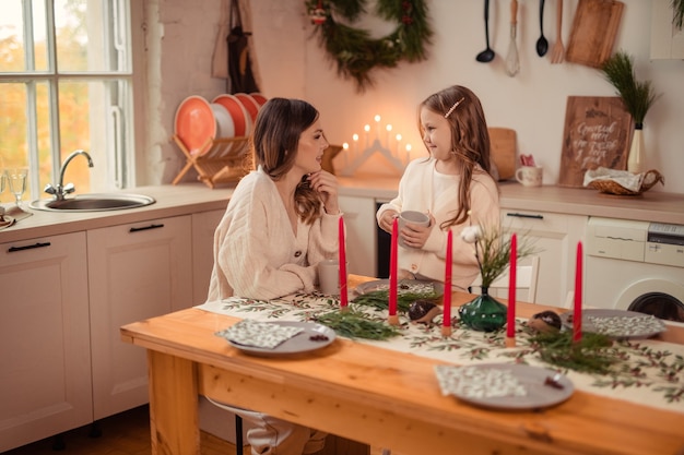 Linda mãe e filha perto da árvore de Natal