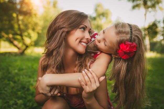 Foto linda mãe e filha se divertindo no parque na primavera.