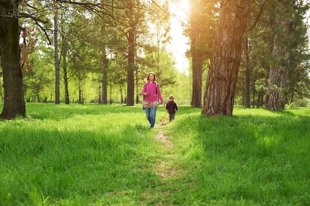 Linda mãe e seu lindo filho caminhando no parque