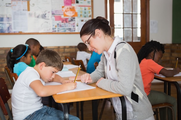 Linda maestra ayudando a los alumnos en el aula