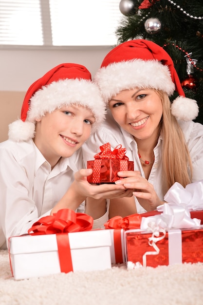 Linda mamá e hijo con sombreros de santa