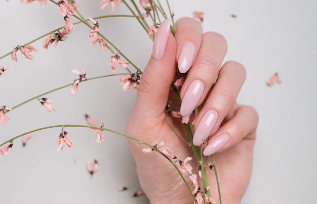 Foto linda manicure feminina e close-up de flores