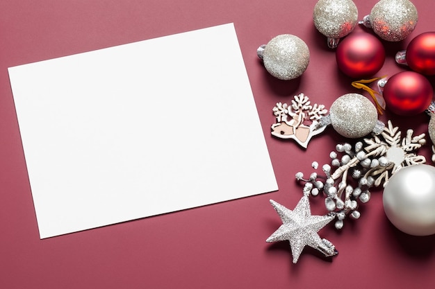 Foto linda maquete de um cartão branco com enfeites de natal na lateral do cartão