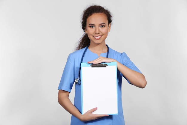 Linda médica afro-americana em fundo cinza