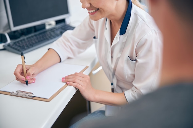 Linda médica alegre durante consulta com homem