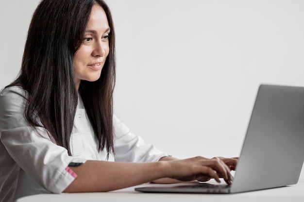 Foto linda médica navegando no laptop