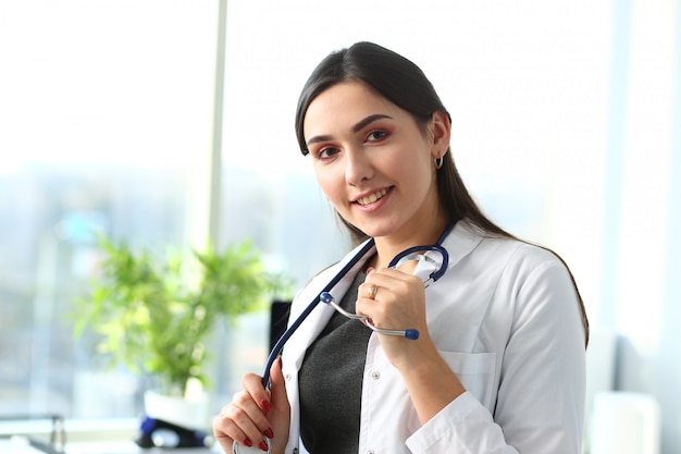 Linda médica sorridente no retrato no local de trabalho