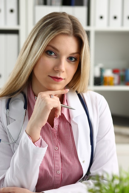 Linda médica sorridente sentada no local de trabalho