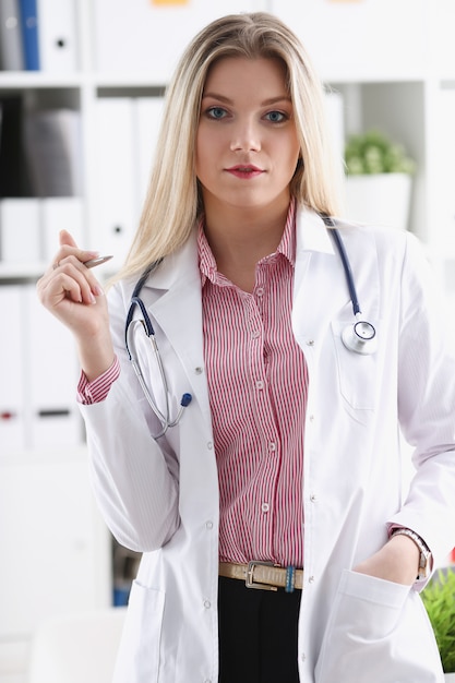 Linda médica sorridente sente-se no local de trabalho