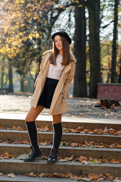 Linda menina adolescente nos degraus em um parque de outono