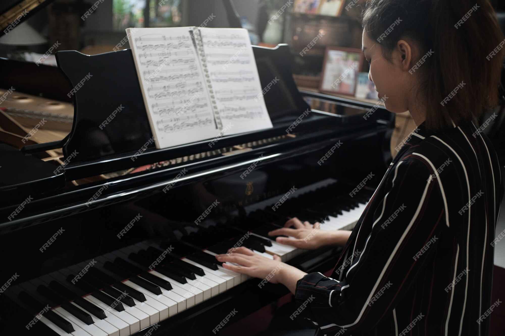 Linda garota asiática aprendendo música de piano online com