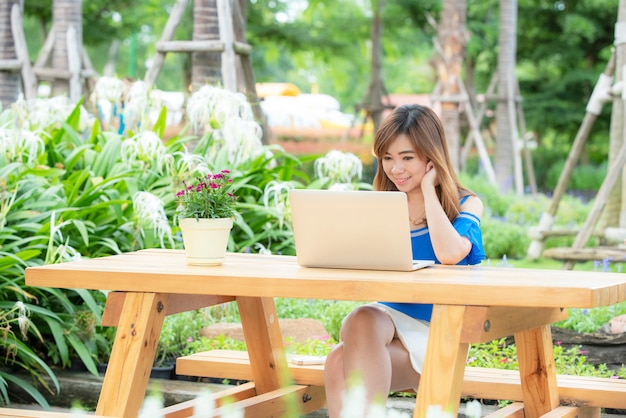 Linda menina asiática comemorar com laptop, pose feliz de sucesso. Comércio eletrônico, ensino universitário, tecnologia de internet ou conceito de pequenas empresas de inicialização.