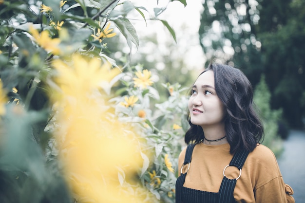 Linda menina asiática em um jardim, sorrindo